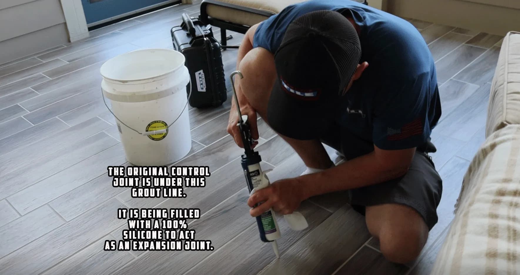 The original control joint in the cement is under this grout line. It is being filled with 100% silicone, which is flexible, to act as an expansion joint. This silicone matches the grout color.